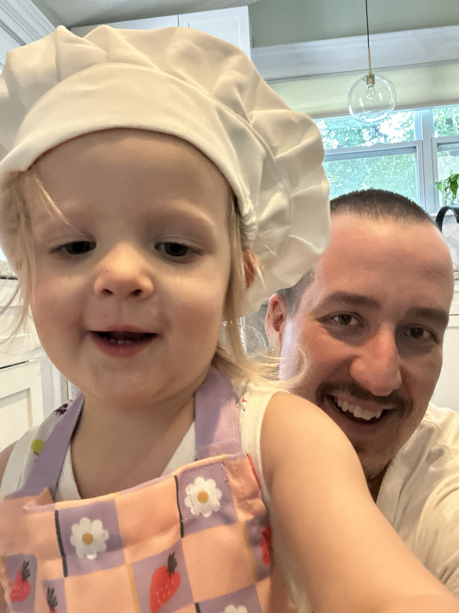 Father with his daughter who is dressed as a chef